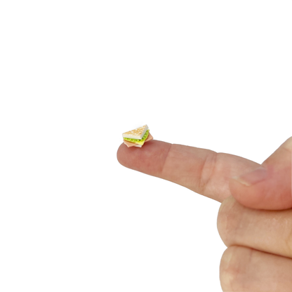 One miniature toy sandwich figurine resting on a fingertip.