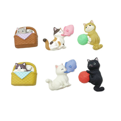 Six cute toy cat figurine magnets. Two are in a picnic basket, two are holding a ball of yarn, and the last two are holding a fish in their mouths. 