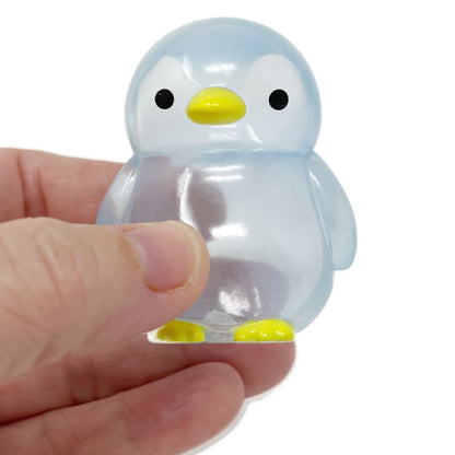 A hand holds a blue translucent squishy penguin toy.