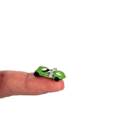 A fingertip with a tiny toy car resting on it.