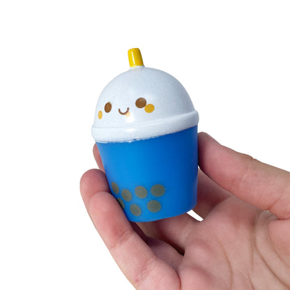 A hand hold a boba bubble tea toy with a cute kawaii face