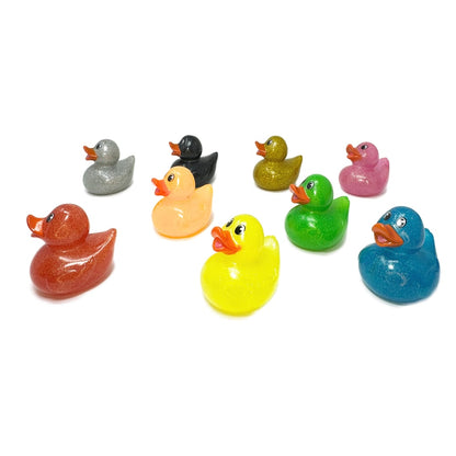 A collection of nine colorful glittery toy rubber ducks looking sideways.