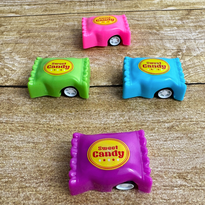 Four bright candy shaped toy cars lay on the table. They say "Sweet Candy" on them.