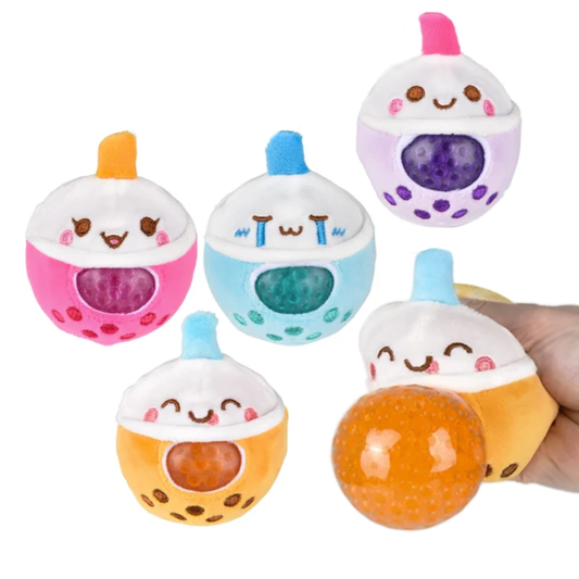 A hand squishes an orange boba plush toy with beads inside. 4 others are in the background and each has a cute face.