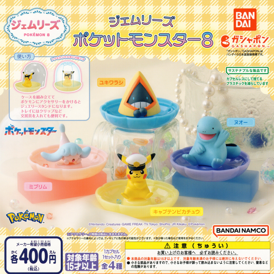 Four collectible Pokemon figures sitting on a plastic tray to hold jewelry or paperclips.