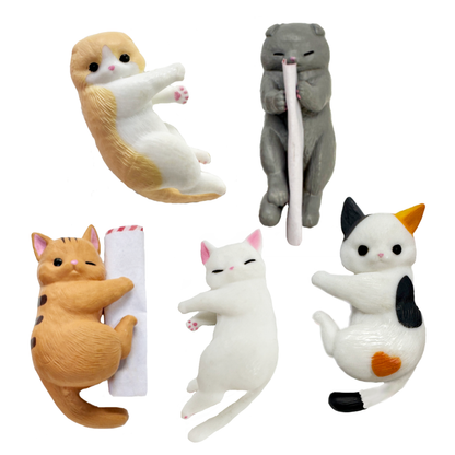 Five toy kitten desk accessories. Scottish fold, Calico, Ginger, and white toy cats are pictured.