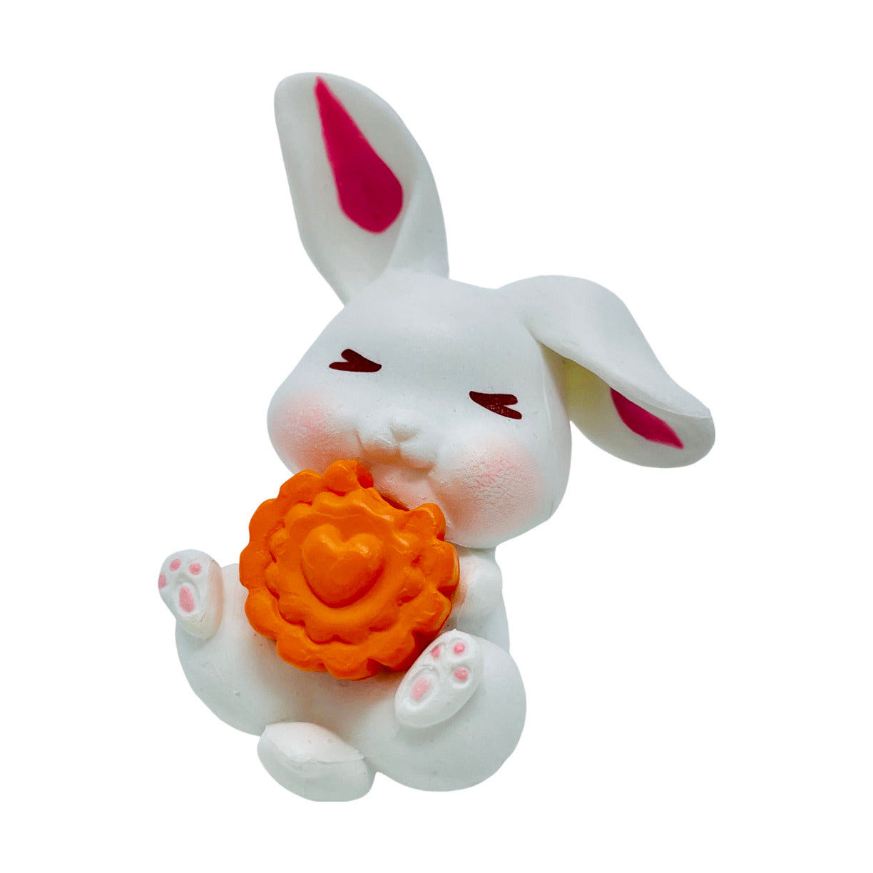 A  white toy bunny figurine holding a carrot slice.