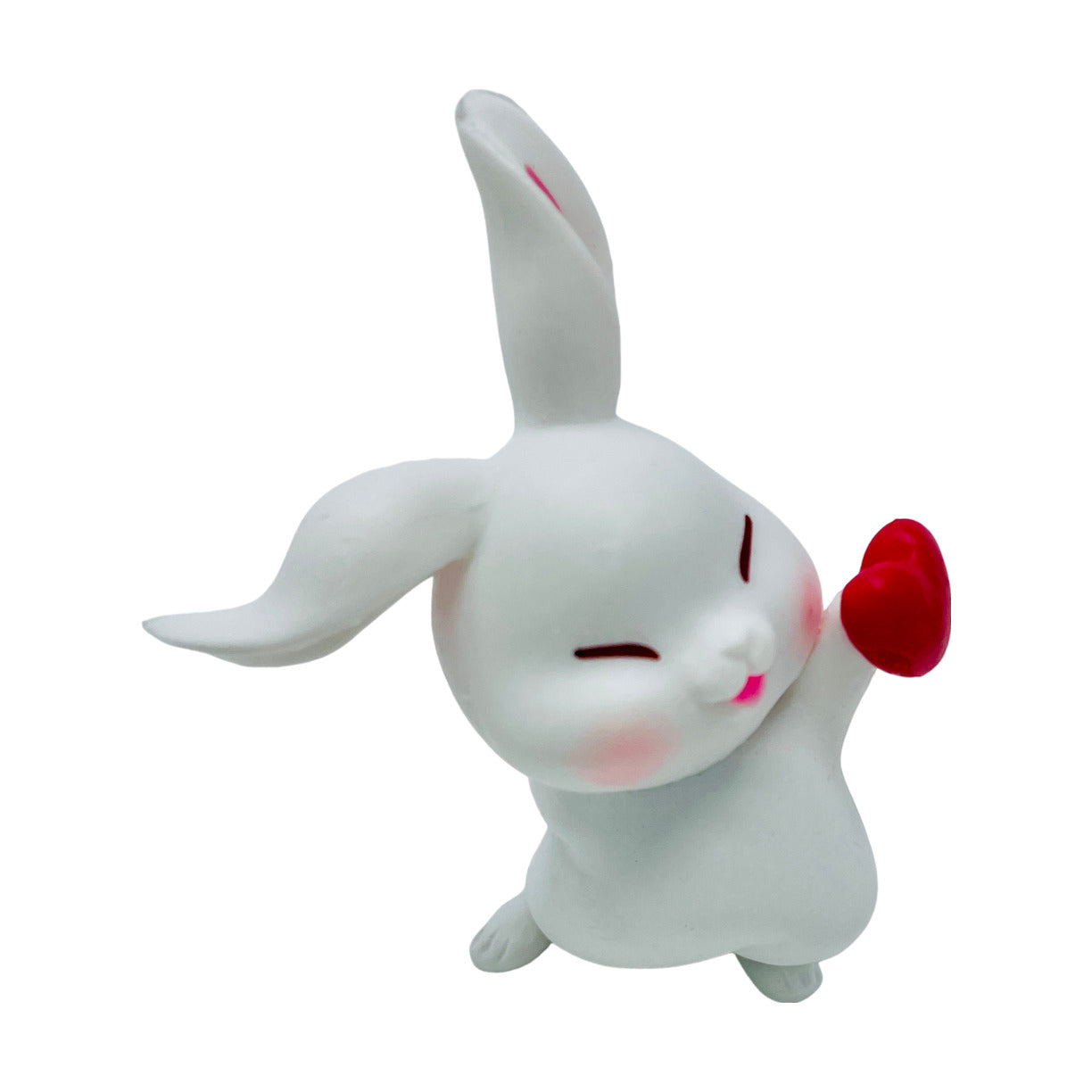 A  white toy bunny figurine holding a heart with one paw.