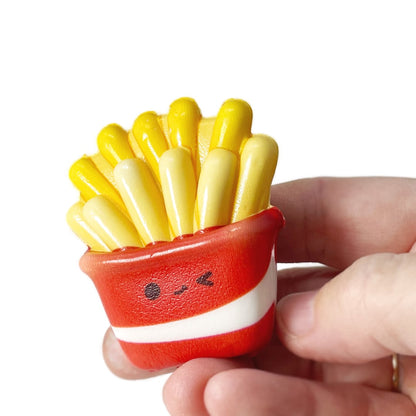 A handing holding a micro squishy fries fidget toy.