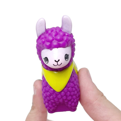 A hand holds a colorful toy llama. 