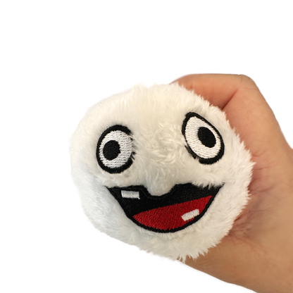 A hand holds a silly faced snowball plush toy.