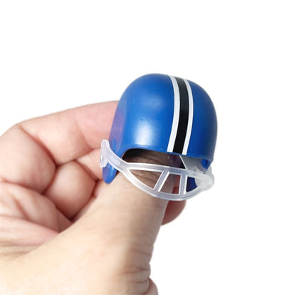 A thumb wearing a blue mini football helmet toy.