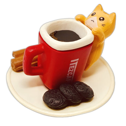 A toy figurine of an orange toy cat with a red toy coffee cup.