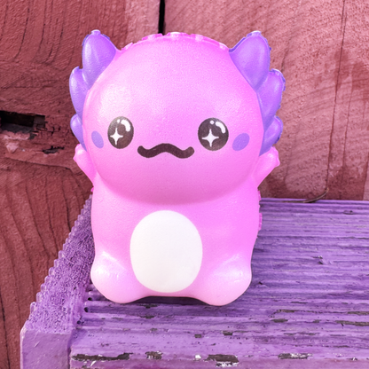 A purple squishy axolotl toy sitting on a purple box